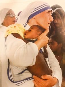 mother teresa holding a baby in her arms