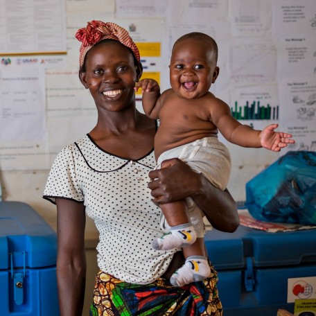 Baby in Zambia smiles with his mother during a medical visit.