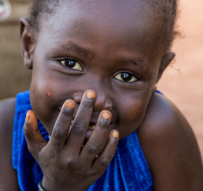 child with hand over mouth smiling gratitude thanksfgiving