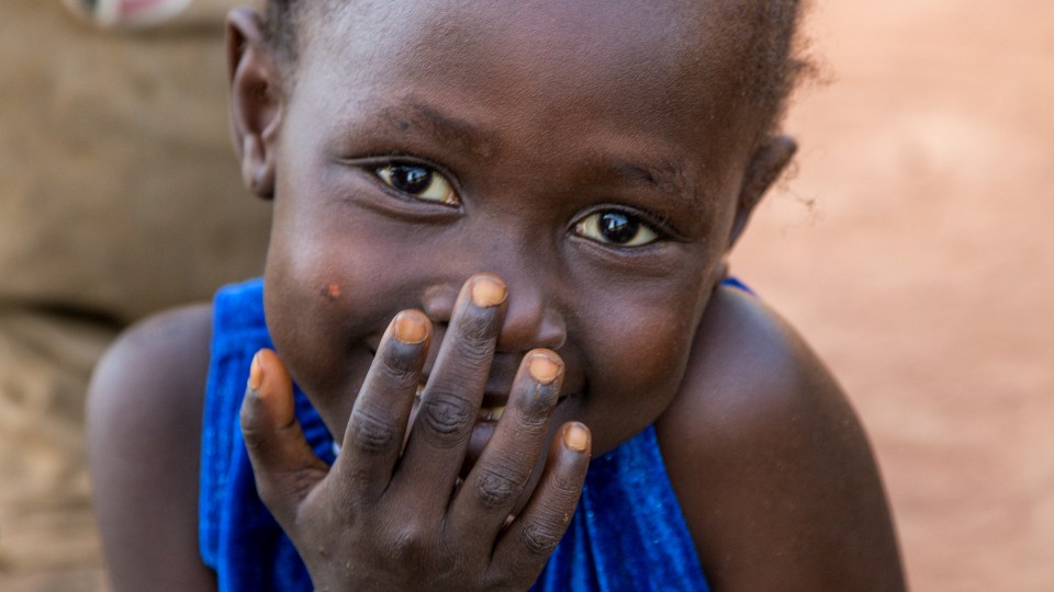 child with hand over mouth smiling gratitude thanksfgiving