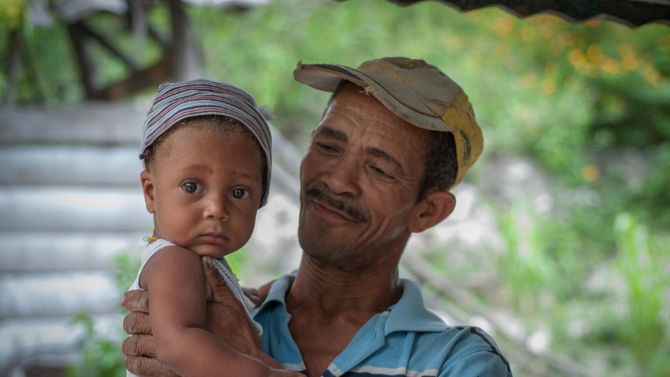 Father Gerald holding baby Djemaley Child needs access to the hospital.
