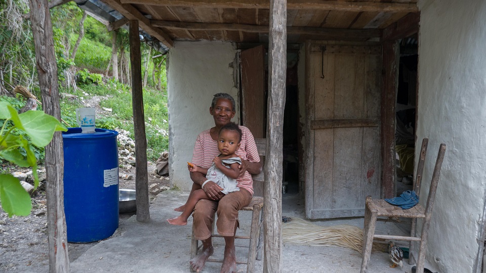 Kevin and his grandmother in front of their home, May 2016