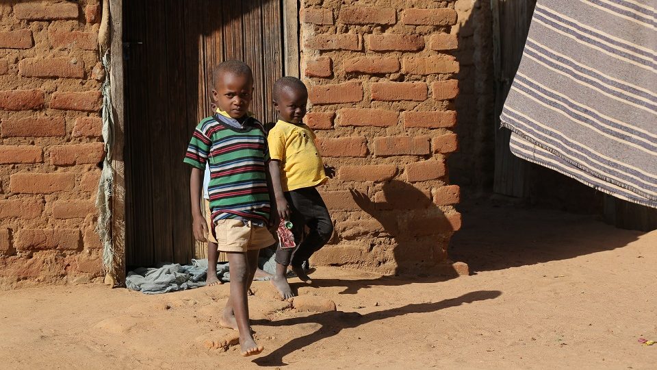 Matheka and his brothers coming out of their uncle's house. They don't have a house of their own. Help a child in Kenya go to school.