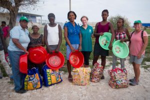 storm in haiti people impacted with bags of supplies and volunteers