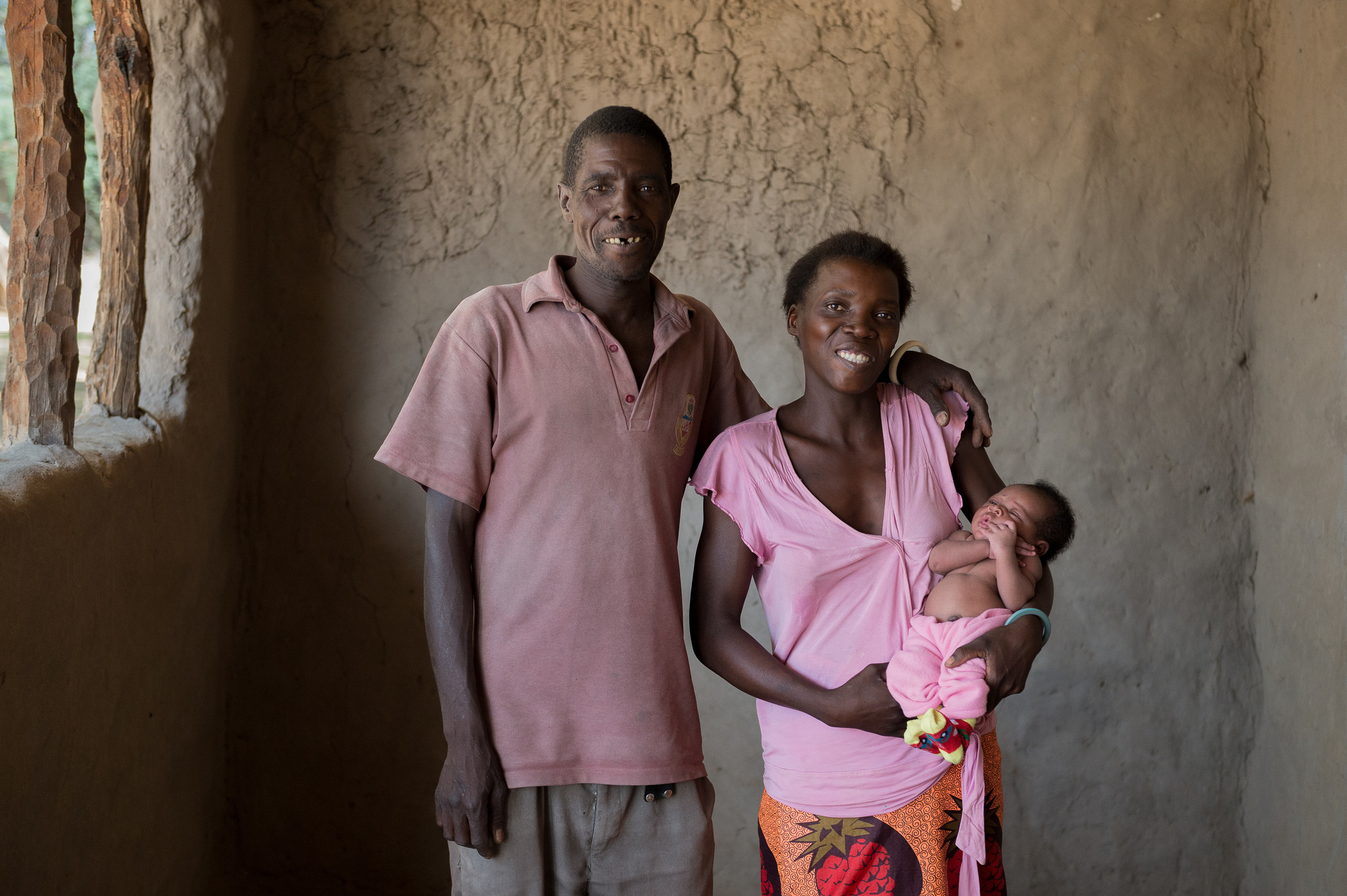 Men taking action in Zambia. A photo of a father, mother and child.