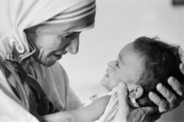 picture of the blessed mother teresa of calcutta, who is now a saint, in black and white, holding a baby.