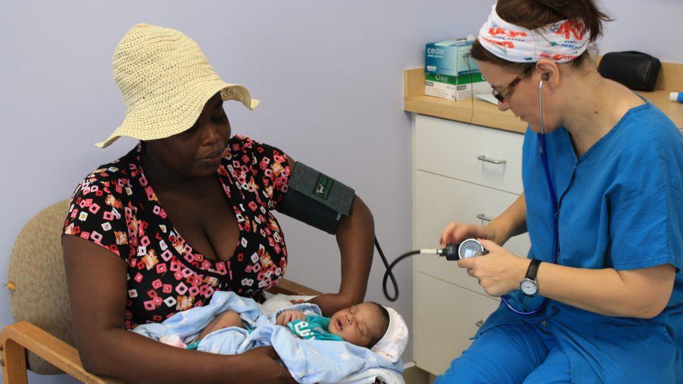 Mercy Health mission team member treating a mother and her baby in Cotes-de-Fer, Haiti