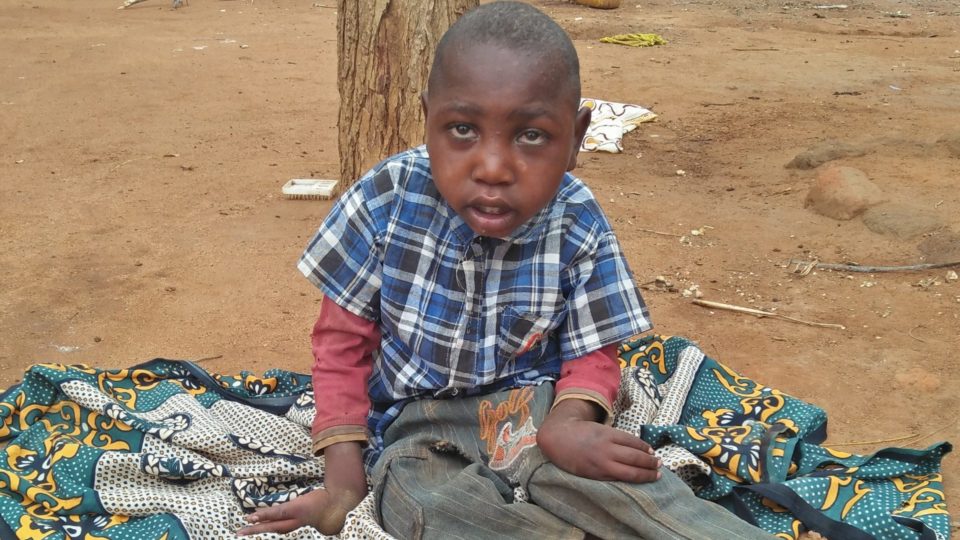 Amos sitting in front of his home.