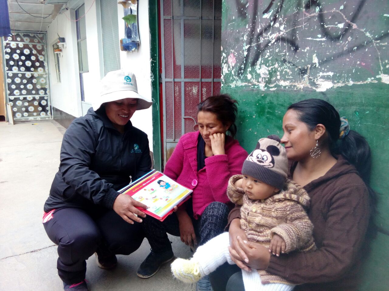 Community health worker, Elizabeth working hard and teaching two mothers about how iron deficiency affects overall well-being