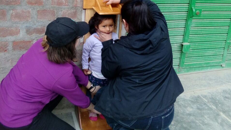 Niki and Nurse Maritza measuring a child in Huancayo