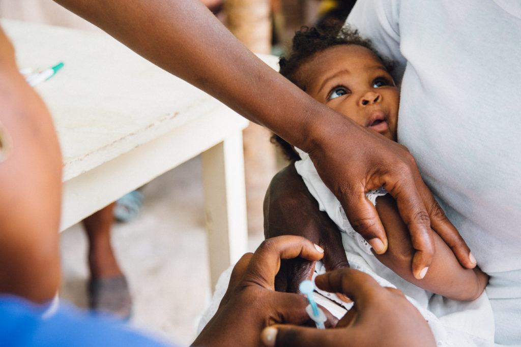 A child receiving a vaccination in CMMB facility in Haiti