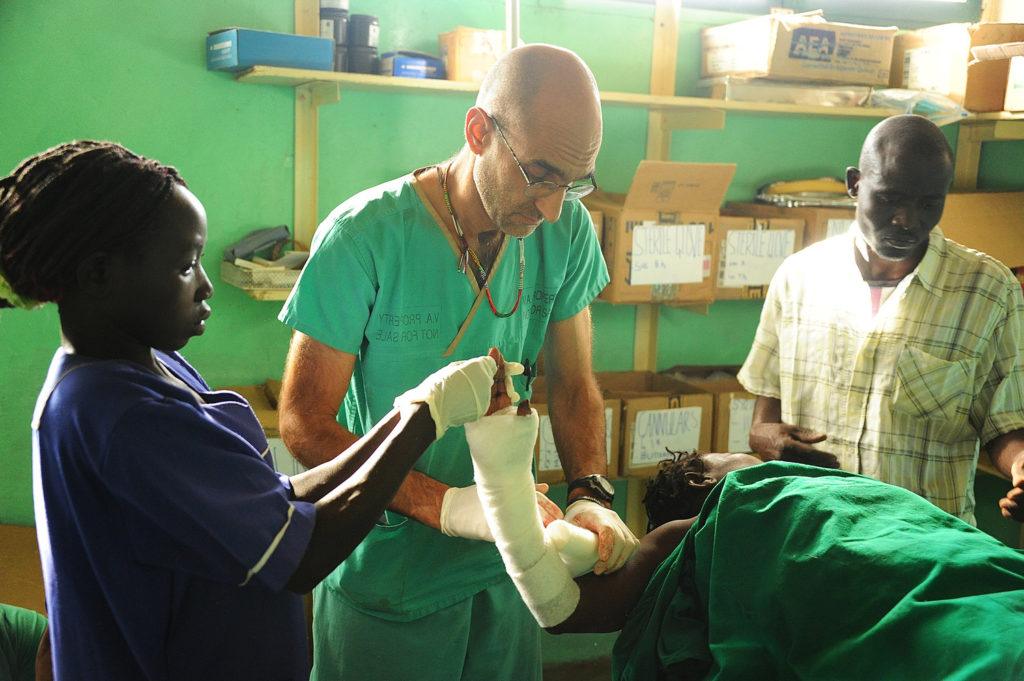 Dr. Tom Catena wraps a patient’s arm during a scene from “The Heart of Nuba” documentary in the Nuba Mountains of Sudan. Catena, a Catholic native of the Diocese of Albany, has served the last 10 years as the only physician at Mother of Mercy Hospital for the region’s 1 million people.