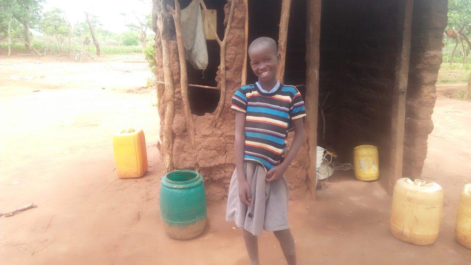 Mawia, smiling outside her home