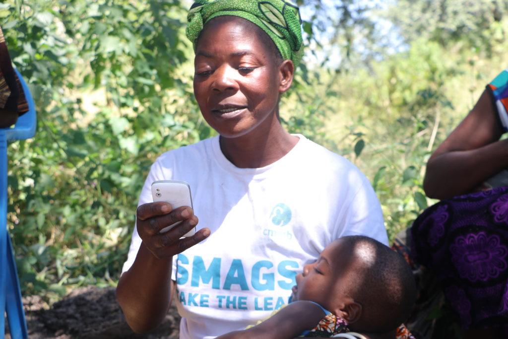 CMMB Community volunteer holding mobile phone