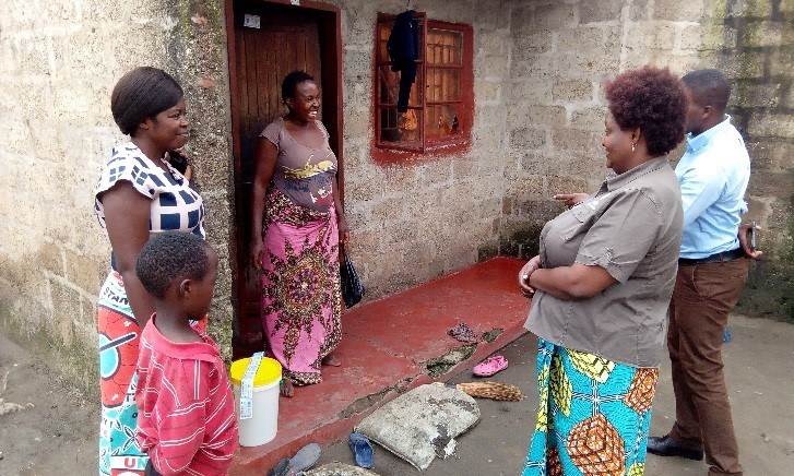 Ms. Walusiku-Mwewa shares a light moment with a beneficiary of the P&G water purification materials during a follow-up with material recipients.