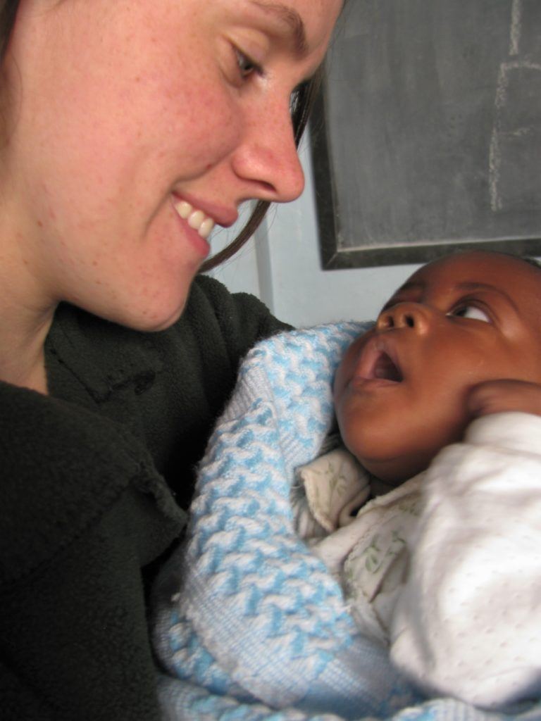 Sarah holding the child of a young woman in Kenya