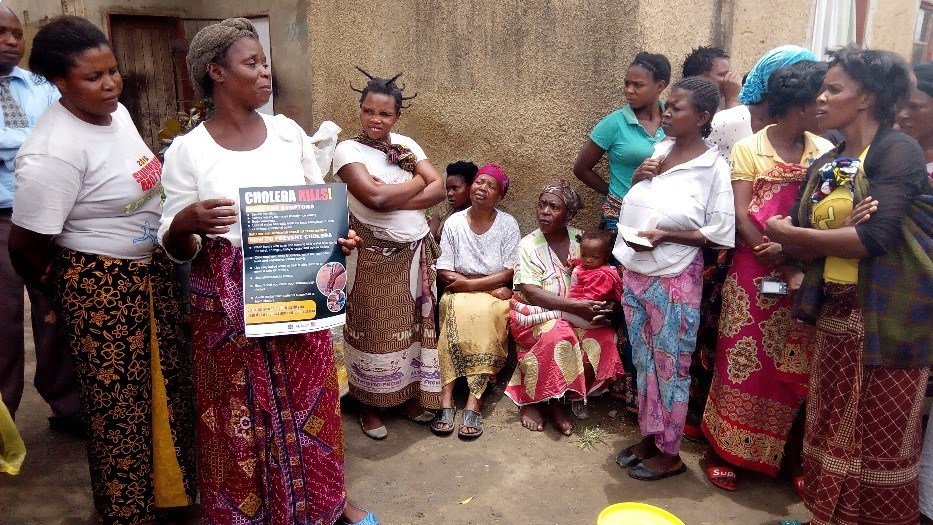 A volunteer educates P&G water purification material beneficiaries about cholera.