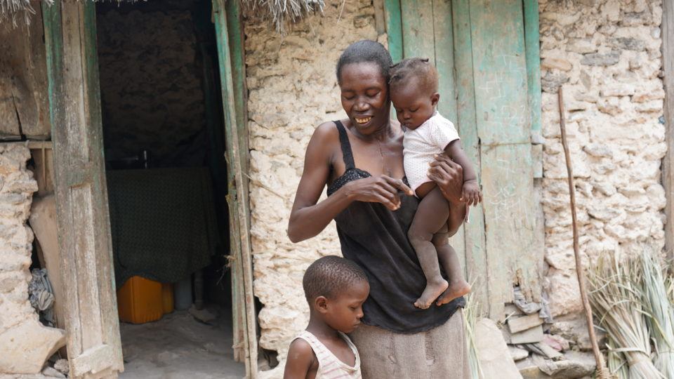 Dieukine standing outside his home in Haiti with his mom, Lorina, and sister, Jean Ali.