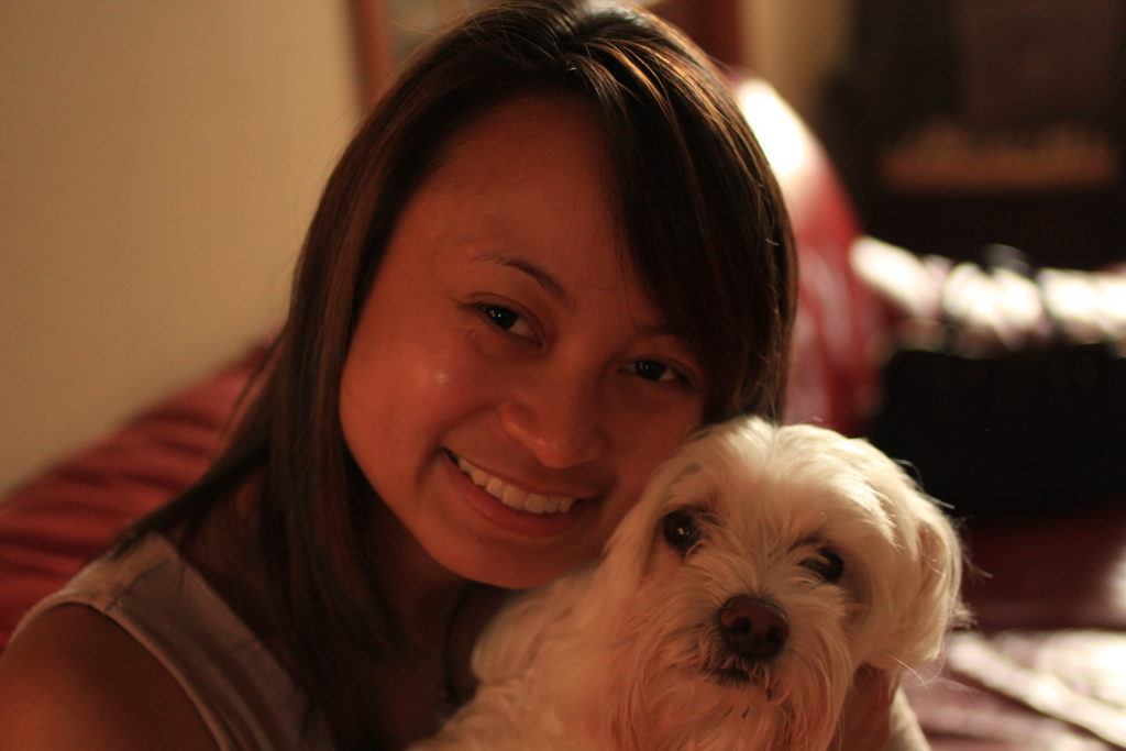 Picture of international volunteer Ellise Carlos with a dog. She will be serving as a registered nurse in Kenya.