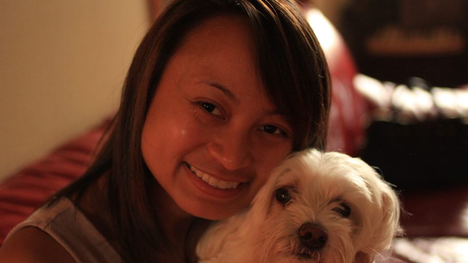 Picture of international volunteer Ellise Carlos with a dog. She will be serving as a registered nurse in Kenya.