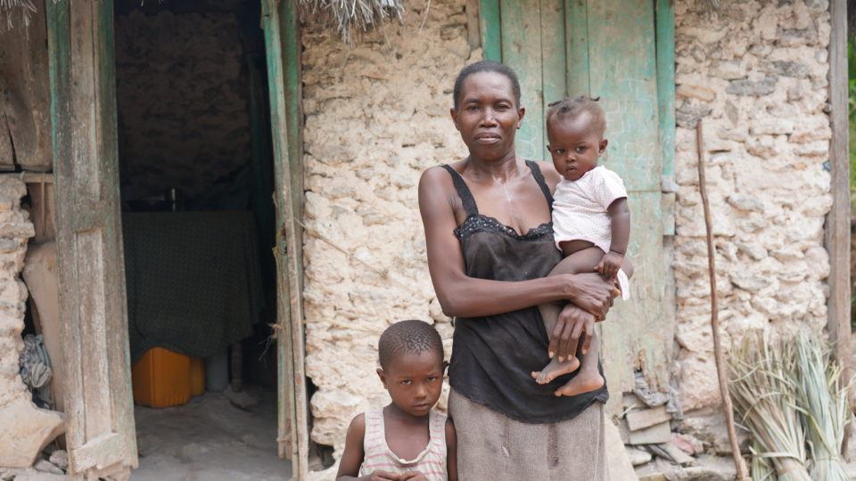 Jean Ali outside of her home in Haiti with her mom, Lorina, and brother, Dieukine.