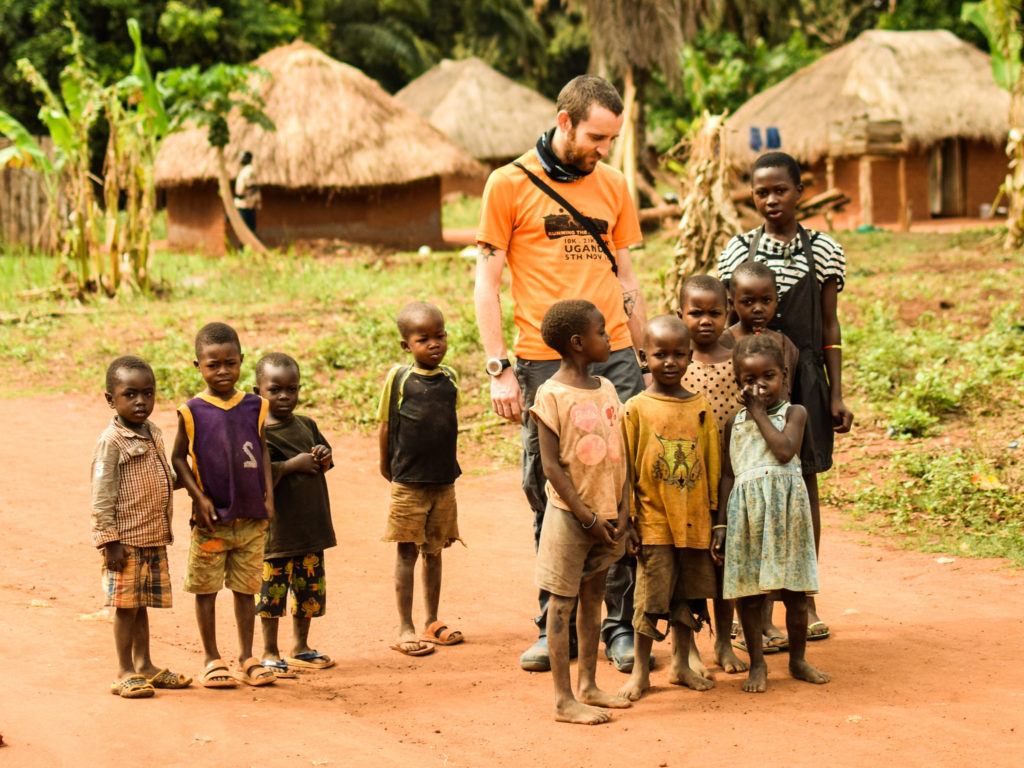 Aurora Fellow Matthew Jones standing outside with a group of kids.