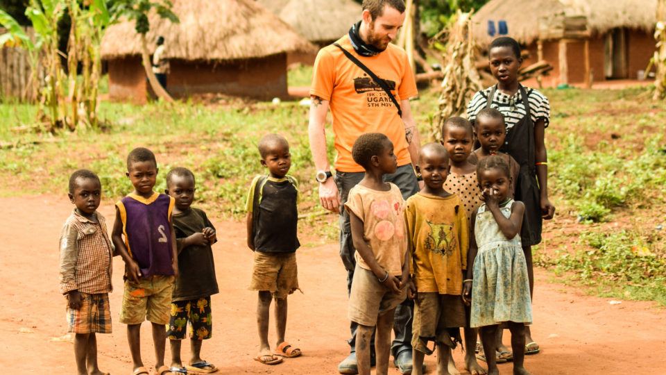 Aurora Fellow Matthew Jones standing outside with a group of kids.