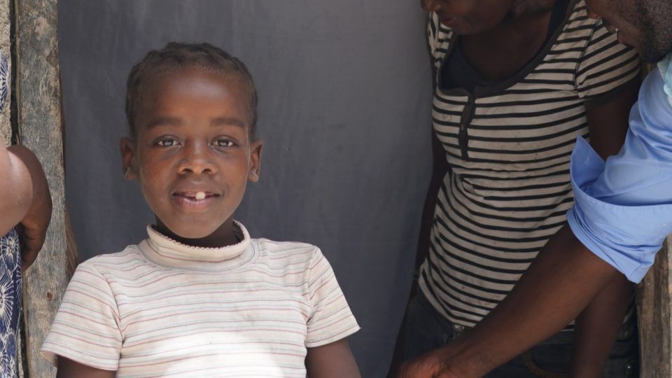 Nadia smiling outside her home during our visit.