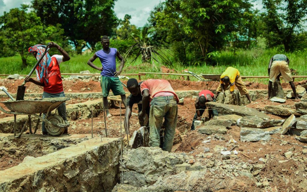 A vivid photo of workers at the St. Theresa hospital expansion in Nzara.