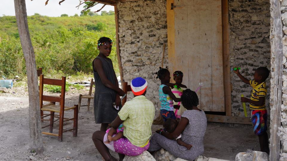 Jonelson with family at their home in Haiti.