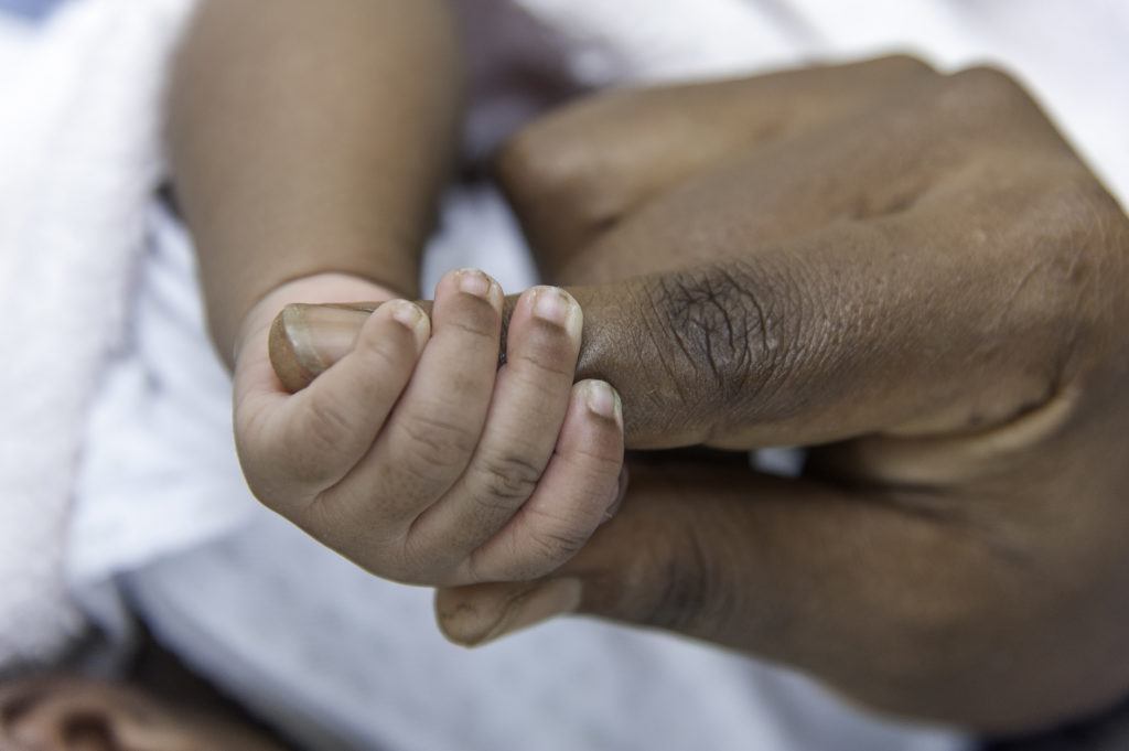 Baby Venredi grasping mom's finger