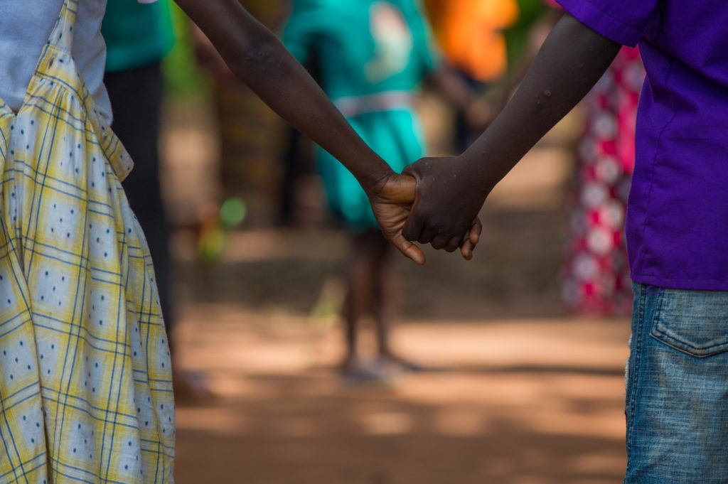 Holding on for peace. Two children hold hands during child protection activities