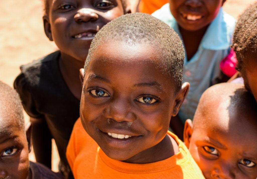 A child in a child friendly space shares a huge smile.