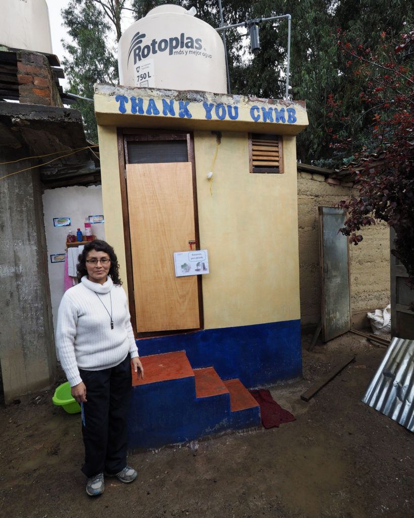 Rayda outside the ecological toilet that CMMB supplied after they successfully completed CHAMPS program