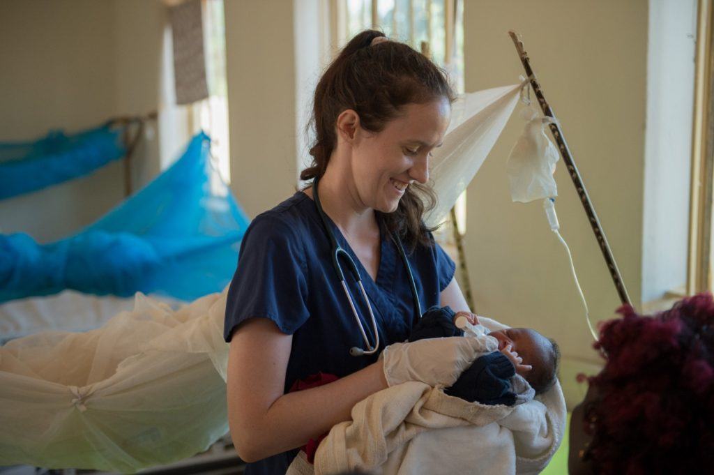 A photo of nurse and midwife, Sarah Rubino, holds a newborn baby in the maternity ward of St. Therese Hospital. 