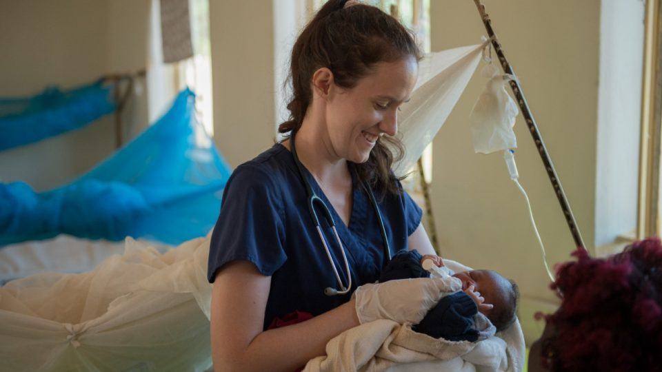 A photo of nurse and midwife, Sarah Rubino, holds a newborn baby in the maternity ward of St. Therese Hospital.