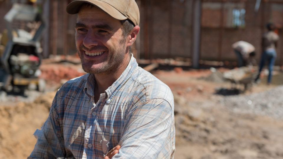 Martin Rubino, a volunteer in South Sudan, stands in front of the hospital expansion site