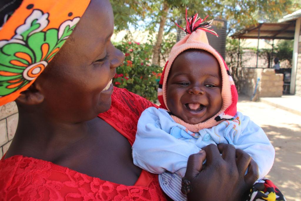 A mother and baby smiling