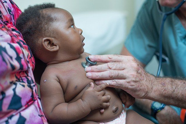 CMMB - volunteer doctor examining baby