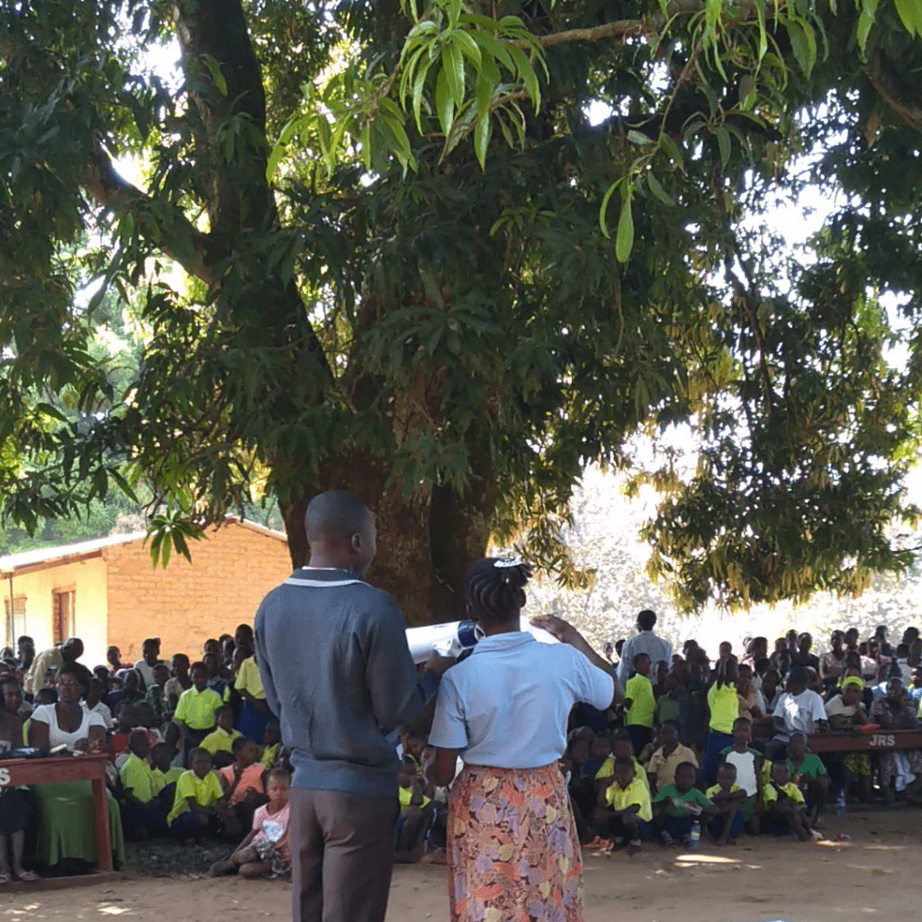 Flora (right) reads out her students’ results at the closing of the 2018 term