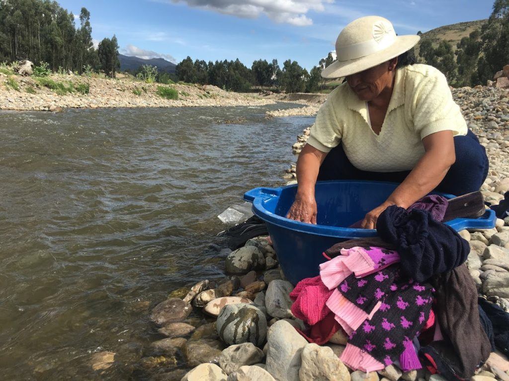 Yolanda washing clothes in the river running through Tambo Huari.