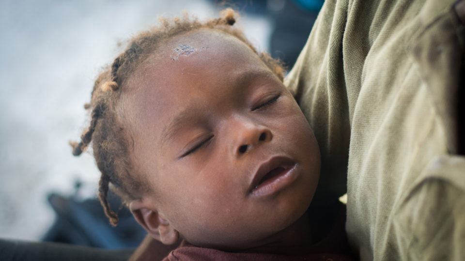A very sick child in Haiti in his mother's arms.