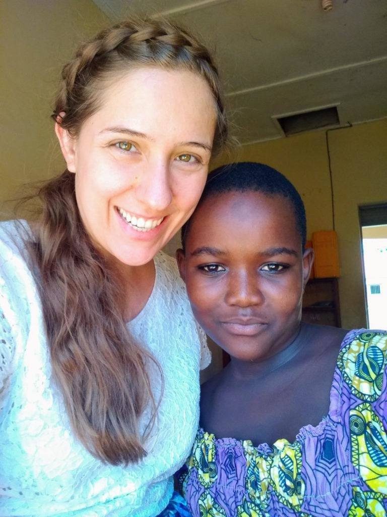 Angela at school, posing for a photo with one of her students 