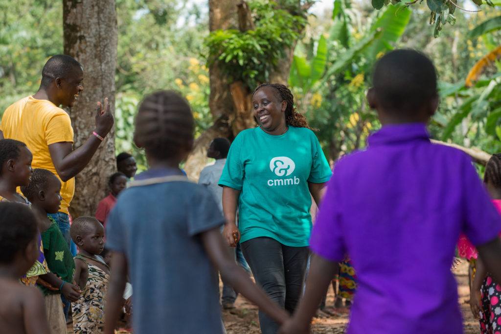 Catherine in a CMMB shirt, leading a CFS activity with community children