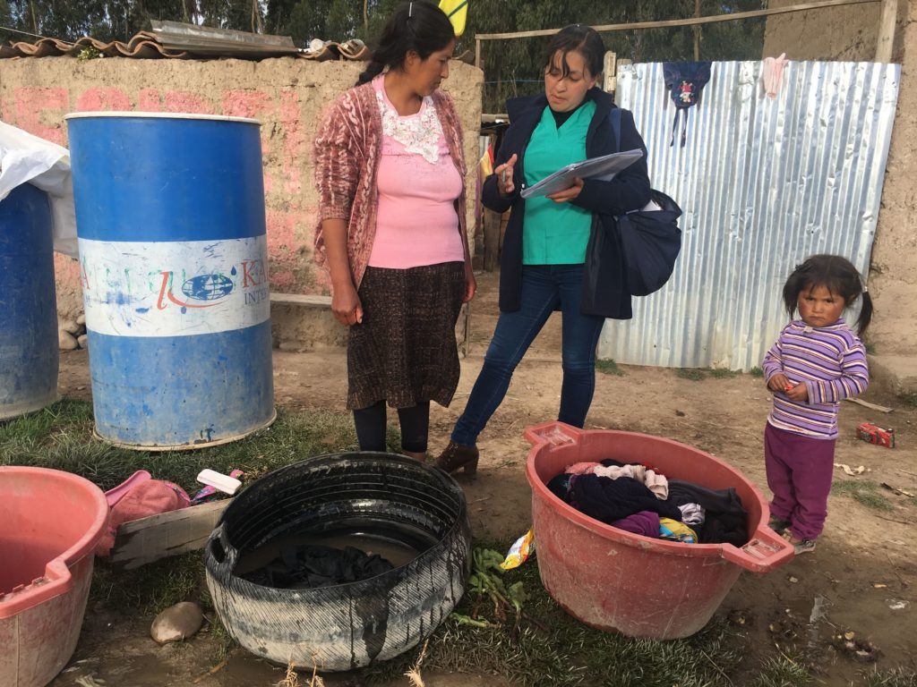 Gina speaking with a community mother, teaching her practices for WASH intervention 
