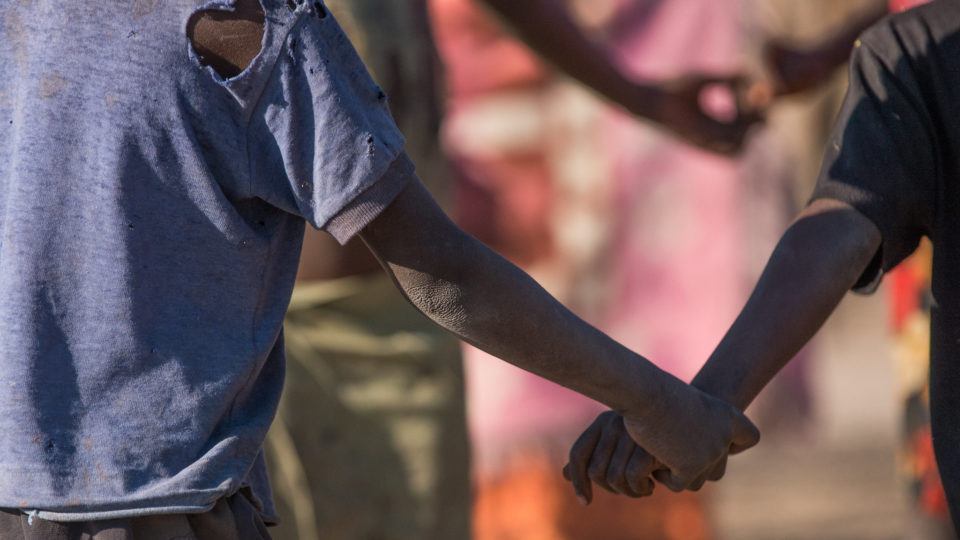 Children holding hands. They are playing in their villiage in Mwandi, Zambia
