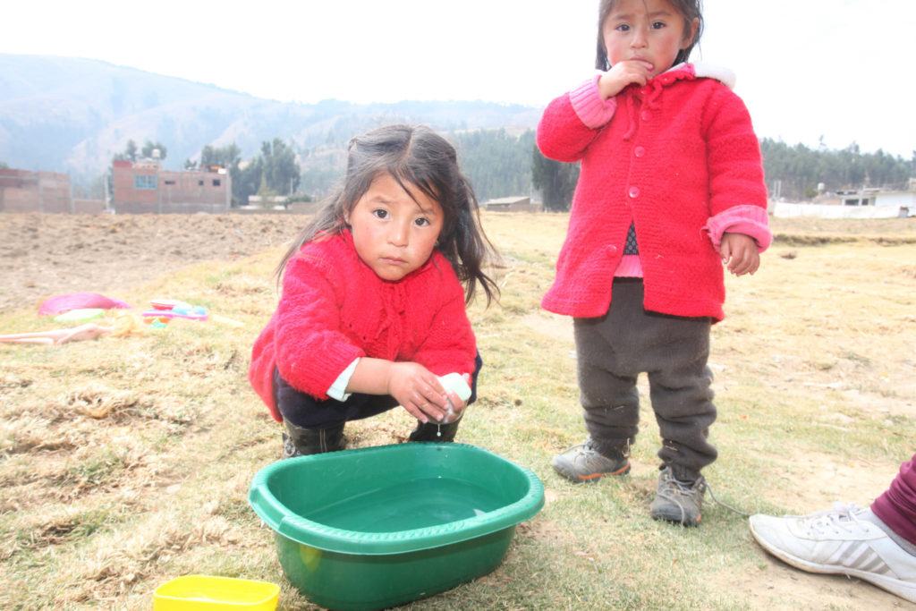 Two girls in Peru washing their hands
