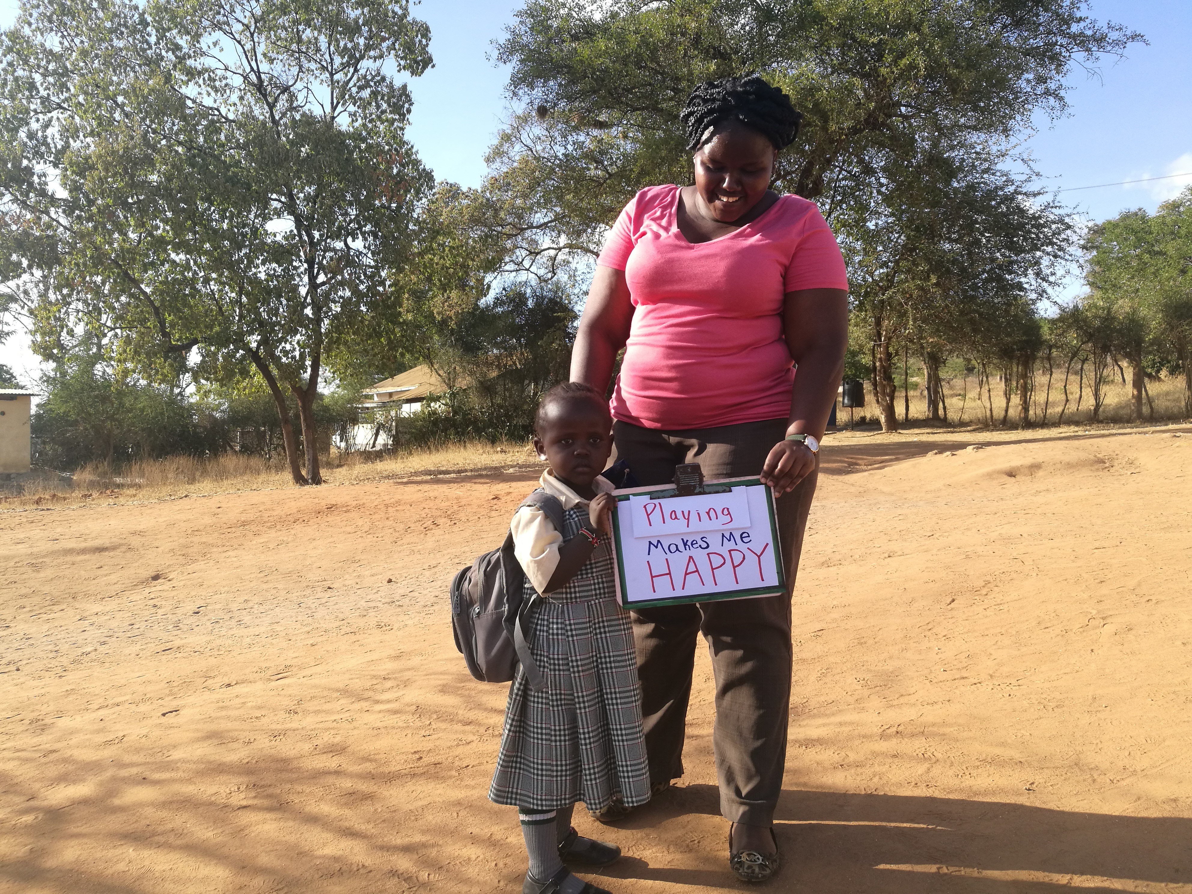 Child and mother with sign in Kenya