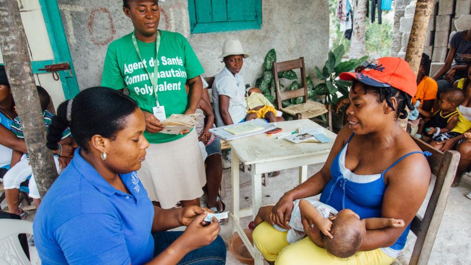 joanne giving a vaccine to a baby