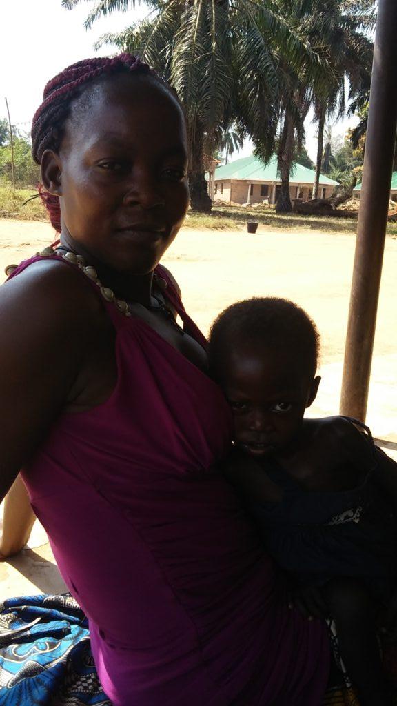 Baby Jenifer sits with her mother outside 